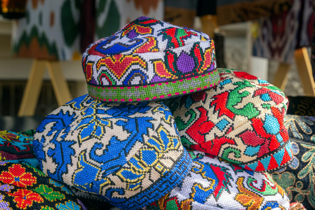 Traditional Asian headdresses with an embroidered colored thread of national ornament in a street market shop