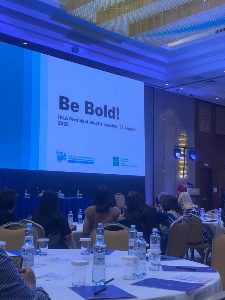 A picture of a projector screen with text at a room with people