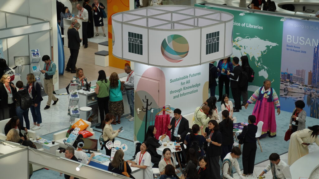 A photo of different groups of people walking around the Exhibition area of a conference centre
